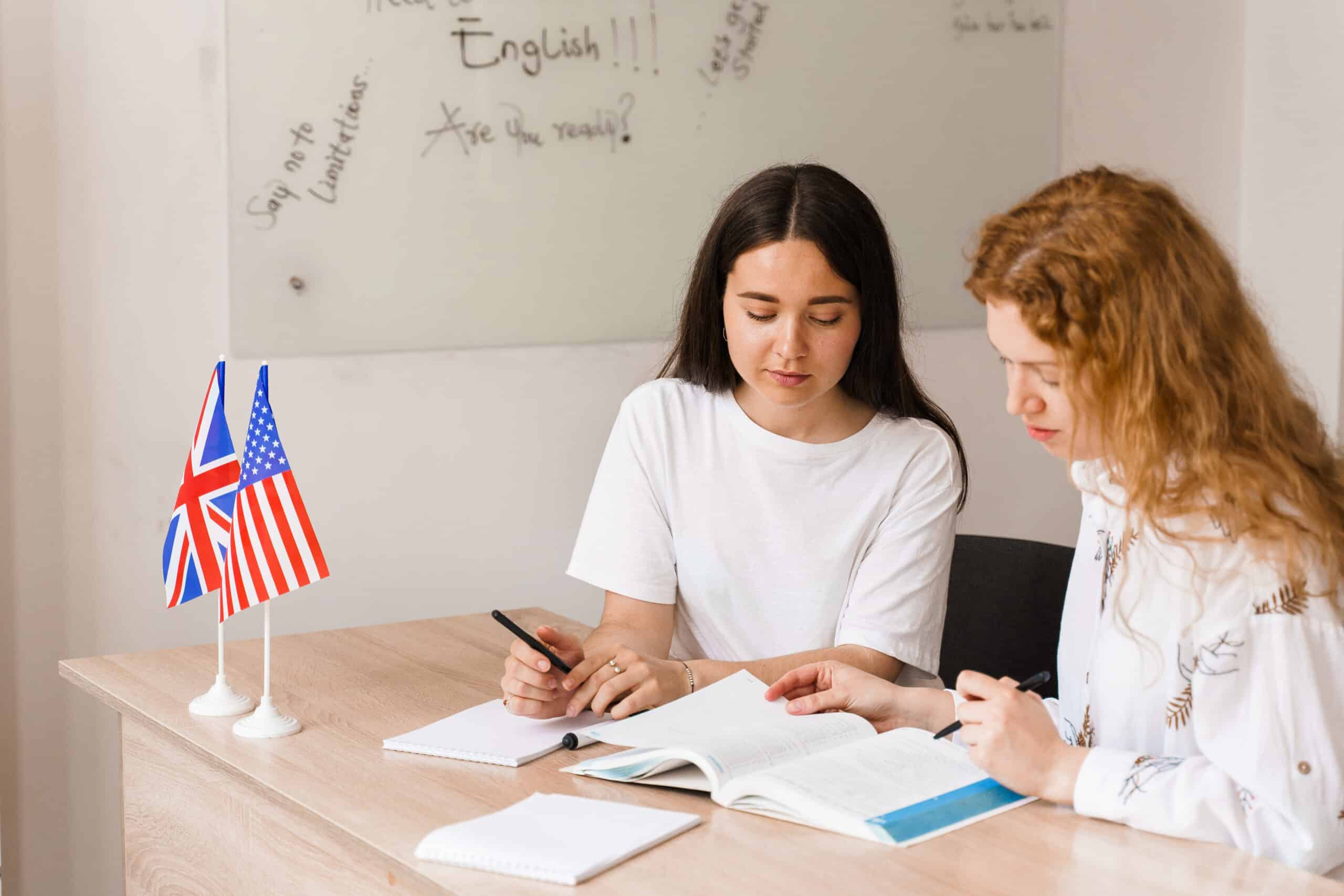 Teacher of english asks student in white class. 2 girls student answers to teacher. Working in group. Study english and british language.
